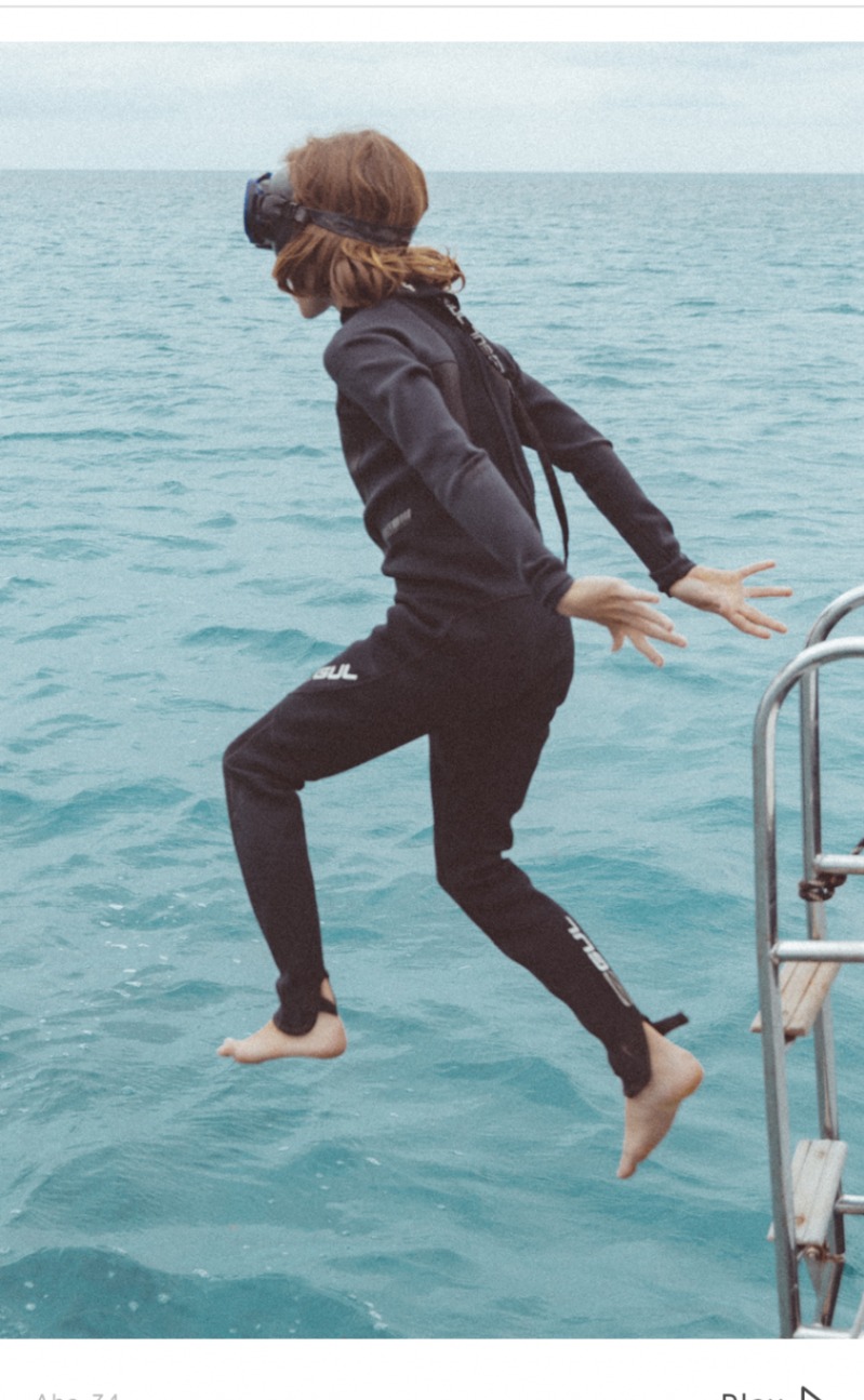 Guest jumping from Sailing Olivia into clear blue water