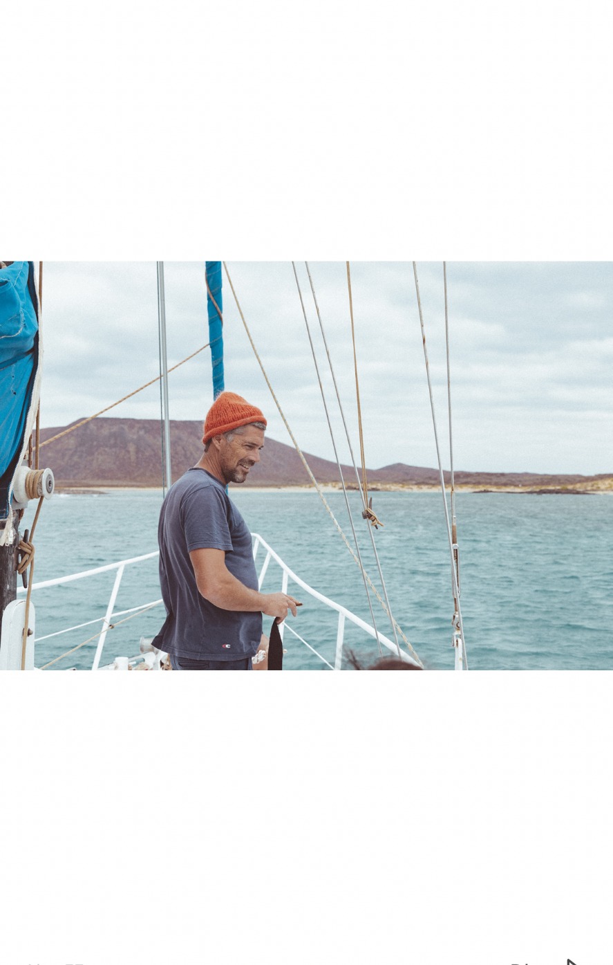 Skipper standing on deck with Lobos Island in the background